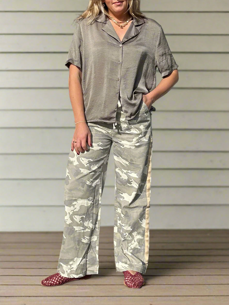 Person standing on a porch with a neutral background